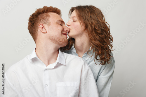 Bild auf Leinwand Young couple in casual clothes shares a tender moment with a gentle kiss on the nose