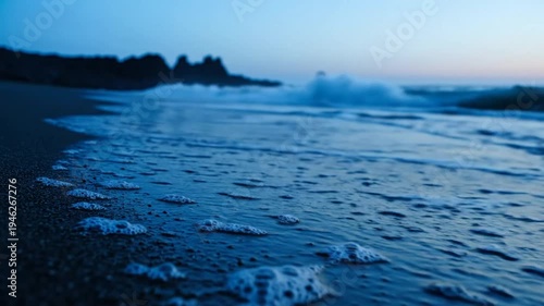 Wallpaper Mural Tranquil coastal scene: Waves gently washing up on a dark sand beach at dusk, serene seascape Torontodigital.ca
