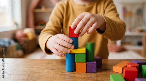 Child stacking colorful wooden blocks on table during playtime