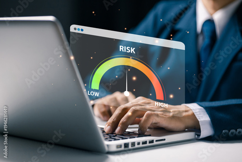 Businessman analyzing digital risk meter dashboard on laptop screen. Concept of risk management, business analysis, financial assessment, decision making and corporate strategy planning.