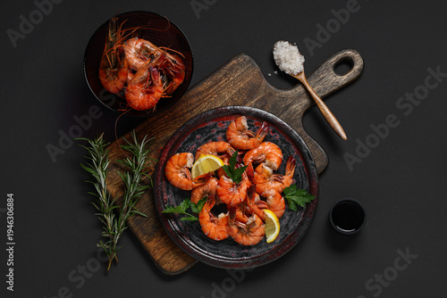 Bild auf Leinwand Plate of tasty boiled shrimps with parsley and lemon on dark background
