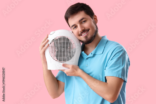 Young man with electric fan...
