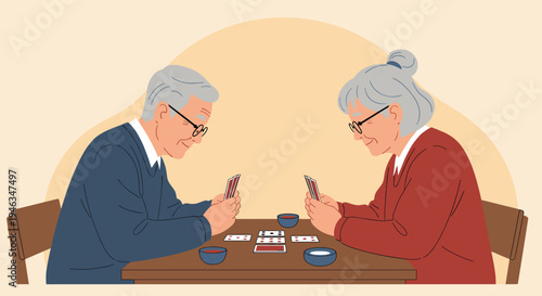 Happy elderly couple sitting together at a wooden table and playing a friendly game of cards while enjoying each other's company at home.