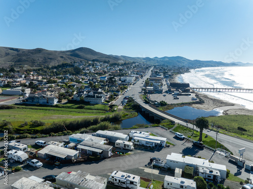 Aerial view of Cayucos, California USA, Pier and Ocean Ave and Shoreline Beach with Green Hills and Central Coast in San Luis Obispo County. High quality 4k footage