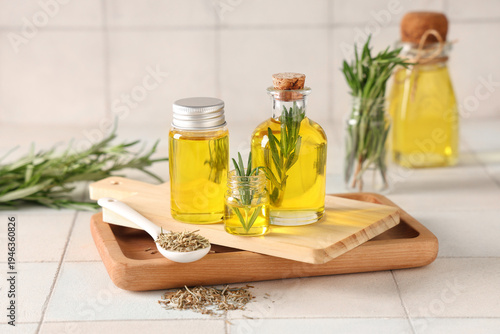 Rosemary with bottles of es...
