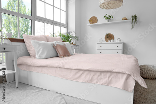 Bed with stylish pink beddi...