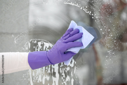 Male worker washing window ...