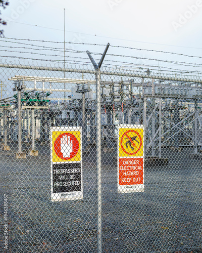 Fotografie Electrical substation with danger hazard signs on security fence
