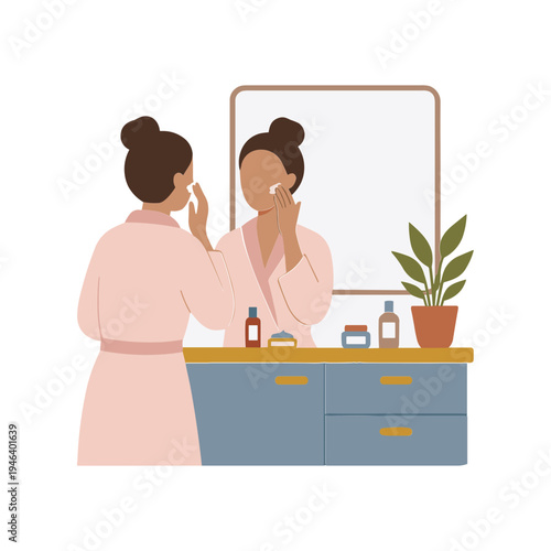 Woman in pink robe applying makeup in front of mirror at home