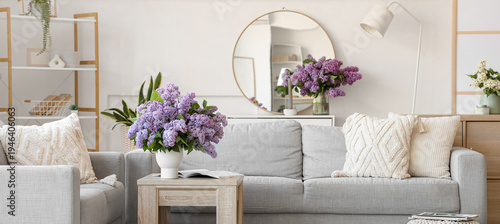 Interior of living room with sofas and lilac flowers in vases