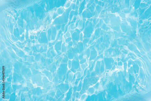 Blue water with ripples on the surface. Defocus blurred transparent blue colored clear calm water surface texture with splashes and bubbles. Water waves with shining pattern texture background.