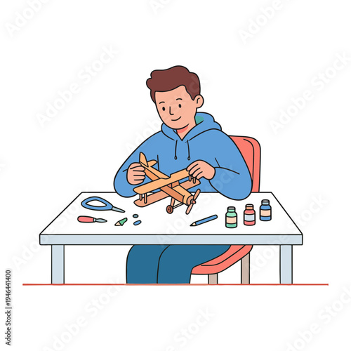 A man builds a wooden airplane model sitting at a table with tools.