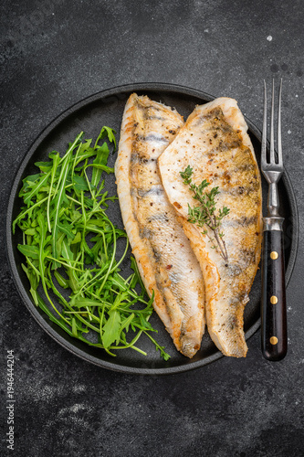 Foto Cooked zander fillets, also known as walleye or pike perch, seared and plated with greens