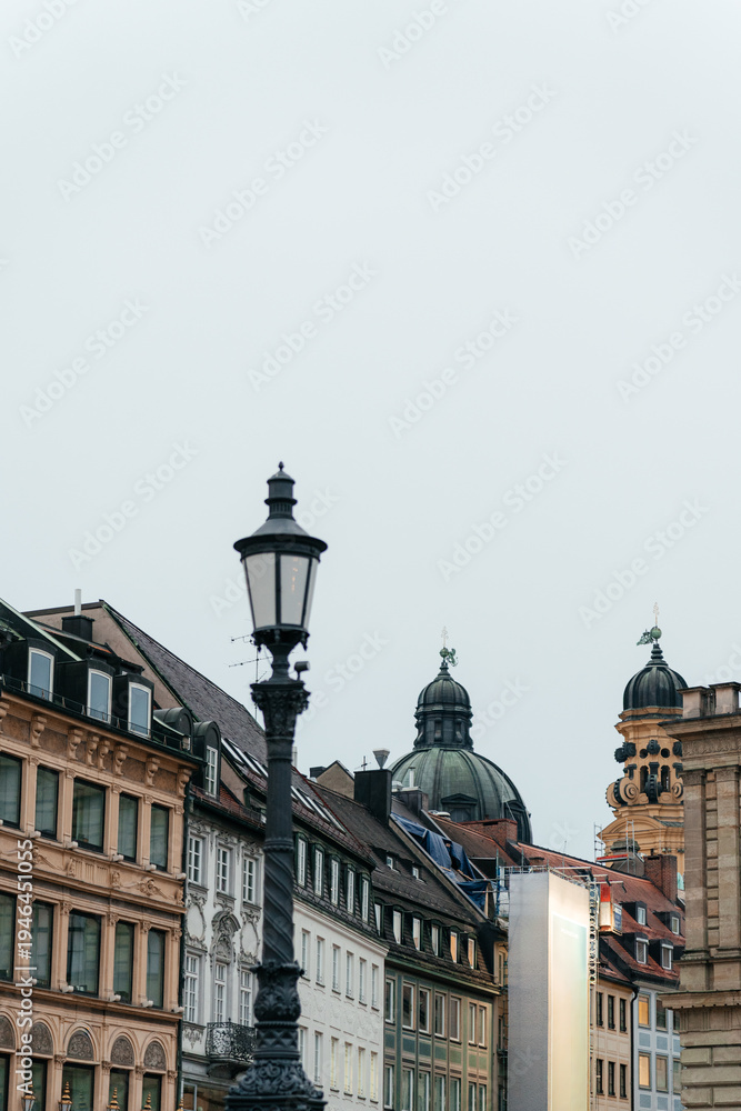 Obraz premium Historic European architecture featuring iconic cathedral towers and traditional buildings in Munich city center. A perfect travel and tourism image capturing culture, heritage, and urban atmosphere