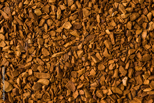 Macro instant coffee granules forming brown textured food background