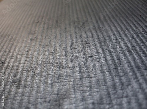 Grey surface of the mattress is slightly damaged.
Grey background with stripes.
Texture of the grey mattress.             