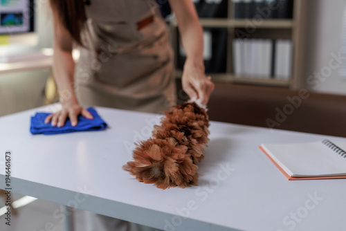 Canvas-taulu Woman dusting office desk for clean workspace maintenance