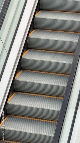 Clean escalator steps climb upward, metallic gray with yellow safety stripes