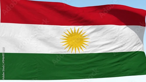 Waving Kurdish Flag with Sun Symbol on Blue Sky Background