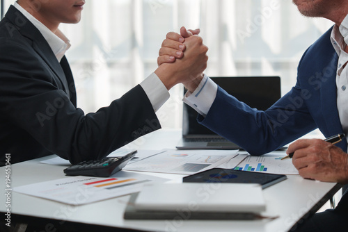 Fotografia Businessmen arm wrestling challenging for corporate success
