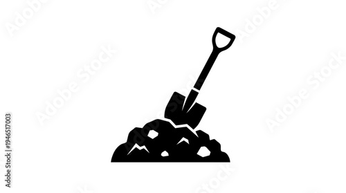 black silhouette of shovel stuck in mound dirt rocks
