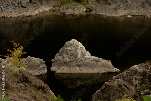 Wallpaper Mural Dark still lake water with large natural rock formations reflecting in the surface at sunset Torontodigital.ca