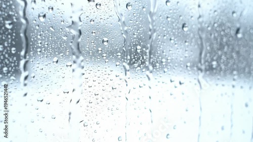 Raindrops Running Down Window Pane in Slow Motion, Blurred Winter Landscape Outside