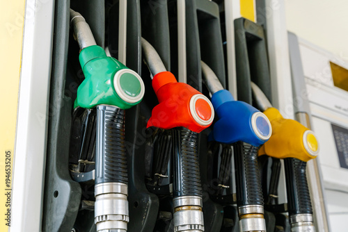 Fuel pump nozzles hanging at a modern gas station during a period of high oil prices. A conceptual photography showcasing the global energy crisis, increasing gasoline costs