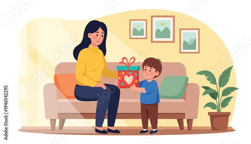 Young son giving gift box to mother on sofa celebrating mothers day at home flat
