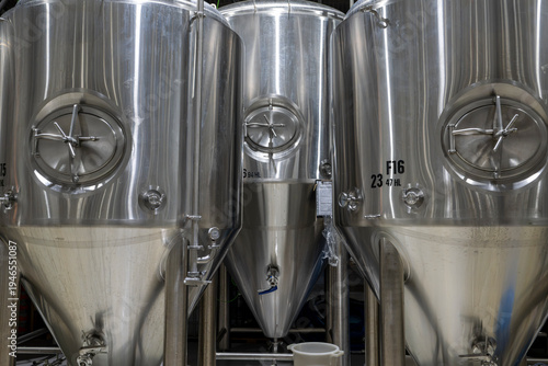 Large stainless steel fermentation tanks inside brewery