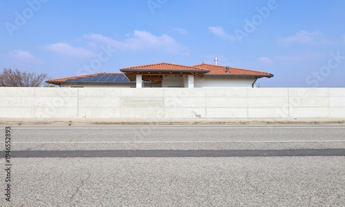 Wallpaper Mural Concrete fence at roadside. Roof and solar panels of residential building on behind. Sidewalk and street in front. Background for copy space. Torontodigital.ca