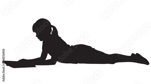 Silhouette of a young girl lying on her stomach and reading a book with concentration and focus. featuring child, studying, learning with education