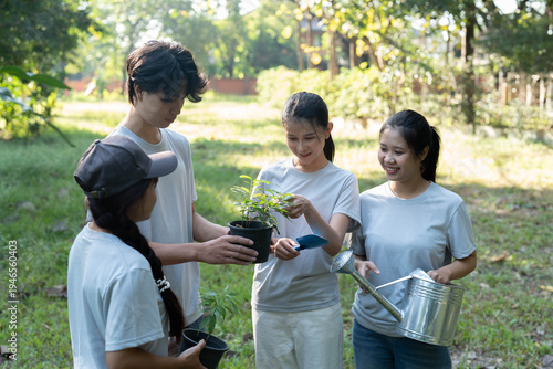 Group of Asian people holding seedling and tools for planting