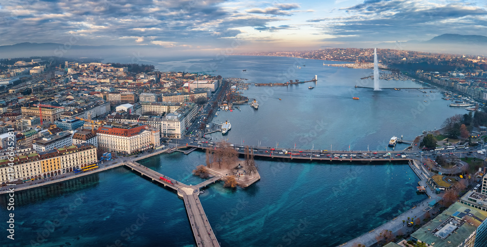 Fototapeta premium Aerial view of the cityscape and lake Geneva, Switzerland, during a winter sunset with fog, clouds and sunshine