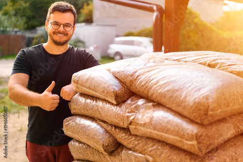 Tableau sur toile Thumbs up man with fuel pellet bags