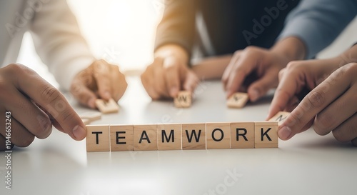Hands holding wooden blocks spelling out teamwork on a table