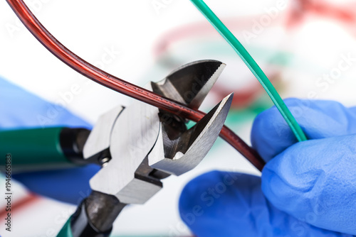 electrician at work with nippers in hand cut the electric cable, electrical wiring. selective focus