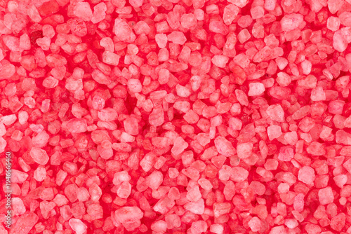Top view of red bath salt crystals forming a beautiful textured background.