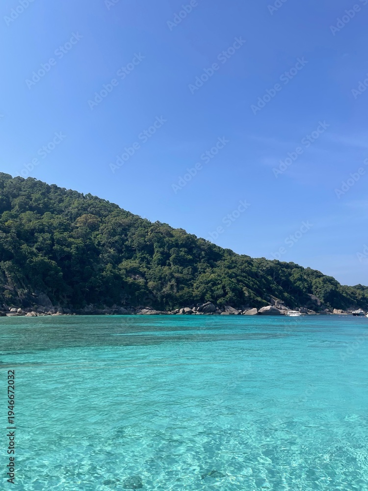 Obraz premium Exotic tropical island with crystal clear turquoise water and lush green hills
