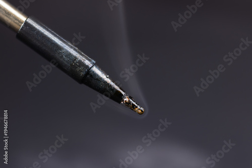 Obraz na płótnie Iron tip of soldering iron with smoke on dark