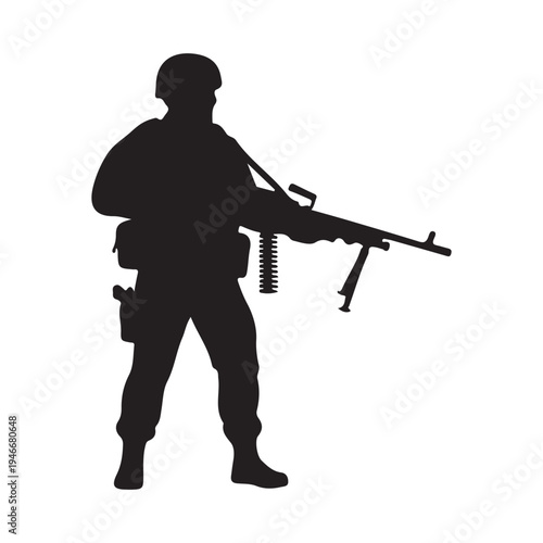 Silhouette of a heavily armed soldier standing ready with a mounted machine gun weapon