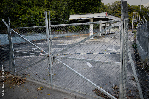 The entrance gate with barbed wire of the abandoned building has been locked