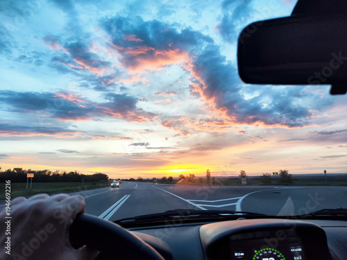 View from the car window during a road trip at sunset with rain in the countryside