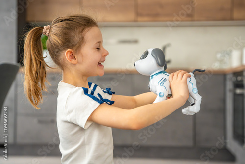 Child hugging robotic dog with affection while sitting on sofa at home. Emotional attachment and digital companionship in modern family life.