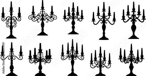 Collection of ornate black silhouette candle holders with candles
