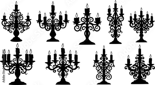 Collection of ornate black silhouette candle holders with candles
