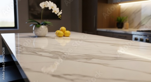 Modern kitchen island features marble countertop with plant & lemons, cabinets, & window