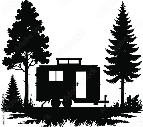 Black silhouette of a camper trailer in a forest with trees
