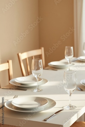 Juego de mesa de comedor minimalista con platos de cerámica blanca impoluta y delicados vasos transparentes