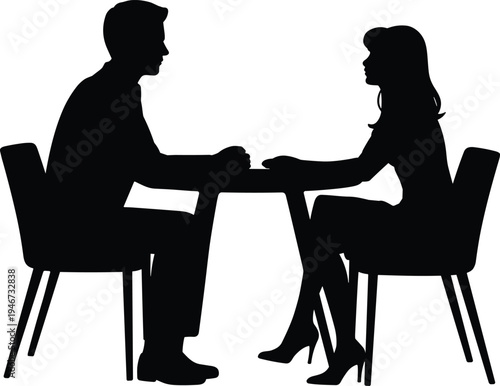 Silhouette of a man and woman sitting opposite each other at a table holding hands suggesting a romantic date or intimate conversation